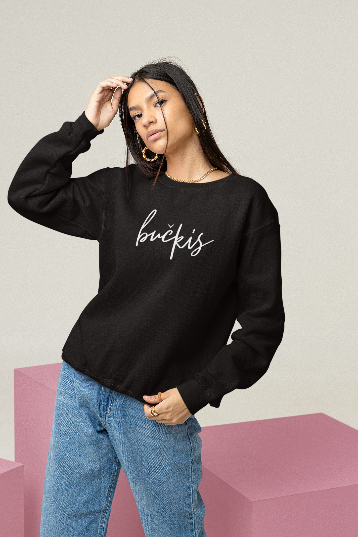 Modelis pozuoja vilkėdama juodą džemperį su baltu ranka užrašytu užrašu „bučkis“ – akcentas madingai tautiškai aprangai.