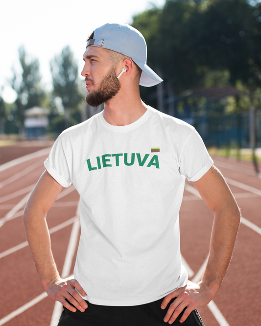 Vyras sporto stadione dėvi lietuviškus baltos spalvos marškinėlius su užrašu „LIETUVA“ ir maža trispalve širdies plote