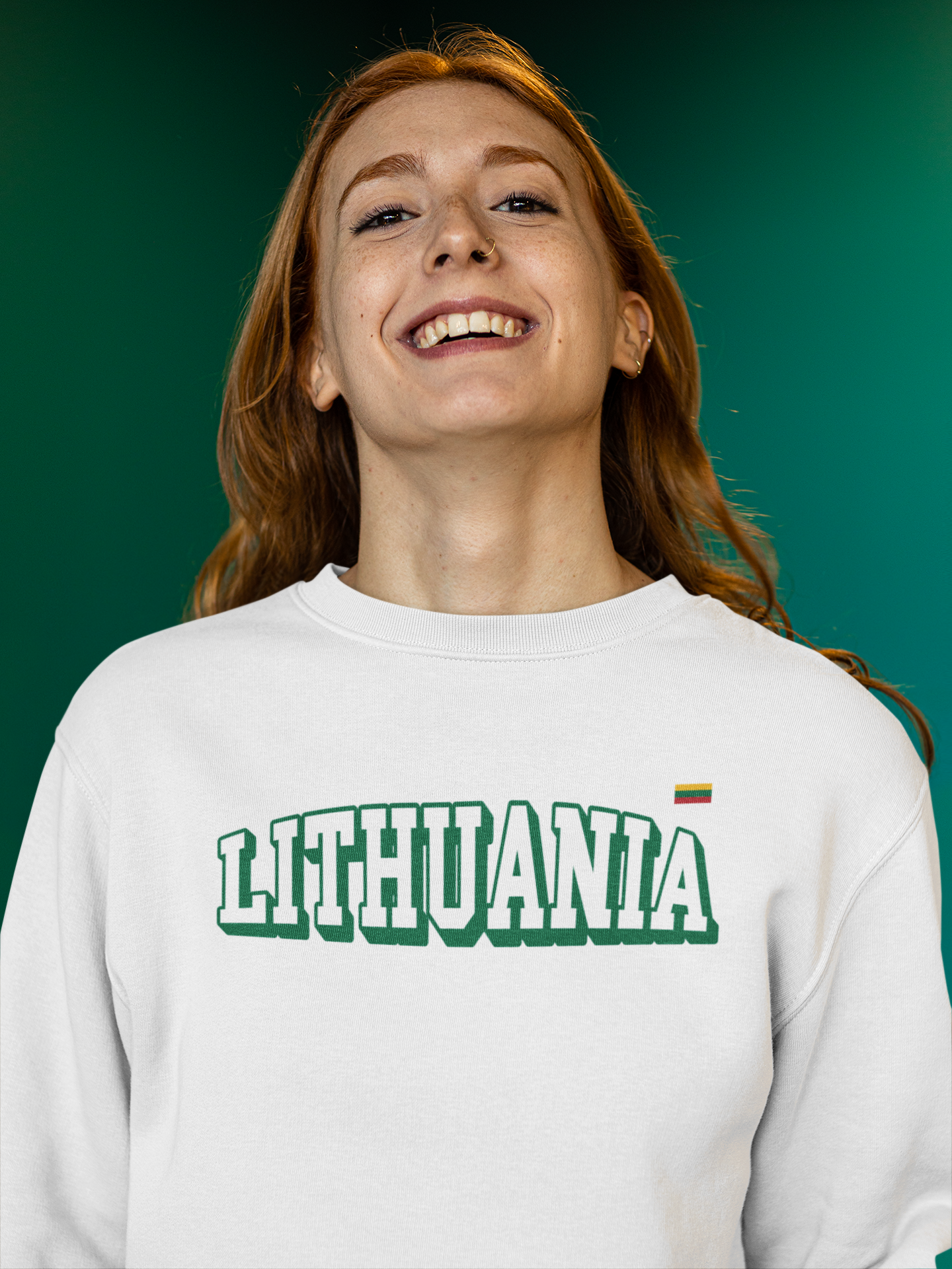 Moteris dėvinti baltą lietuviškos tematikos džemperį su žalio kontūro užrašu "Lithuania" ir Lietuvos vėliava, šypsosi