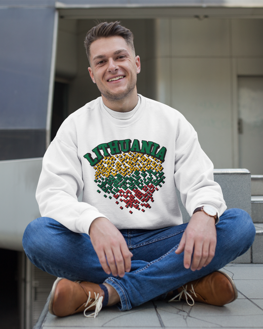Lauke sėdintis vyras dėvi baltą džemperį su užrašu „LITHUANIA“ ir širdies formos dizainu Lietuvos vėliavos spalvomis
