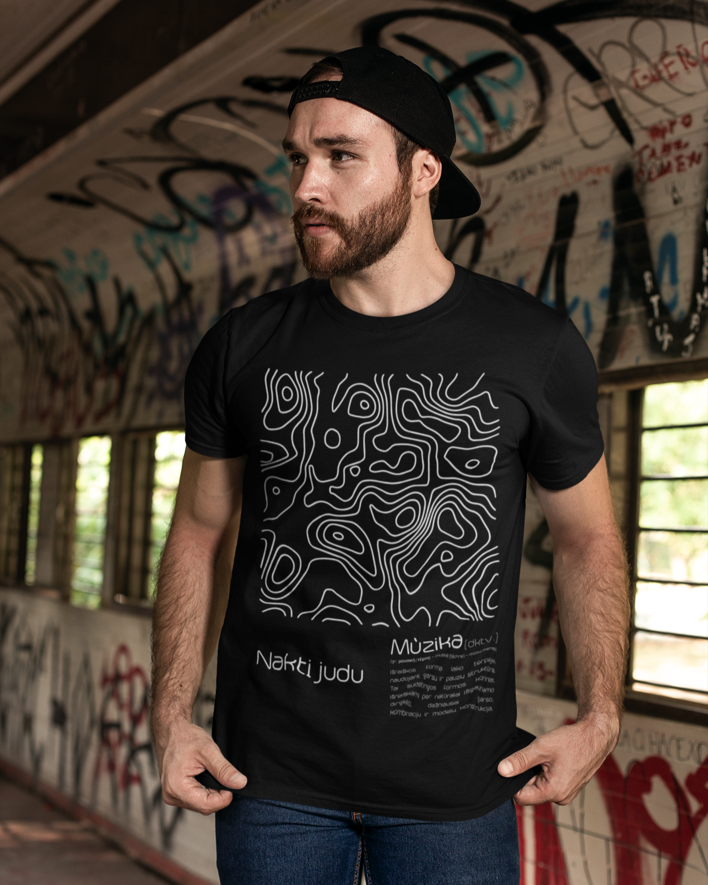 Modelis vilkintis juodus marškinėlius su šiuolaikišku baltos spalvos muzikinės kultūros įkvėptu abstrakčiu grafiniu dizainu.