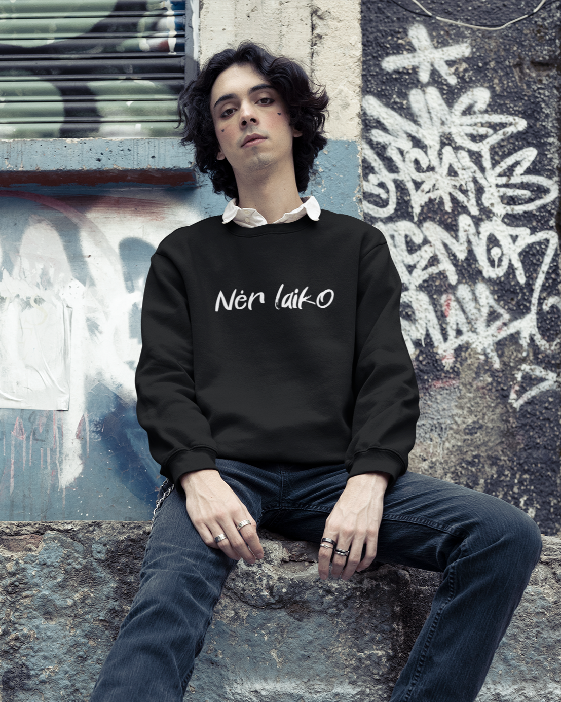 Jaunuolis vilkintis juodą miesto stiliaus džemperį su užrašu - "Nėr laiko", vyrauja graffiti fonas ir rokeriška nuotaika