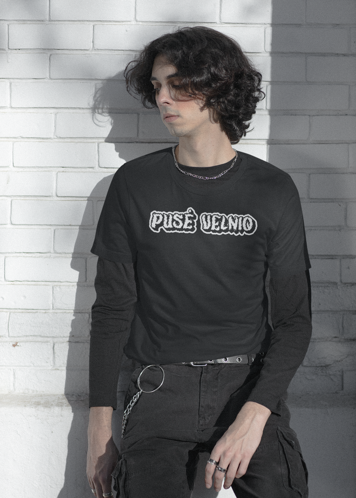 Jaunuolis dėvi juodus marškinėlius su dažnai lietuvoje vartojamu posakiu - „Pusė velnio“, užrašytu gotikinio stiliaus šriftu.